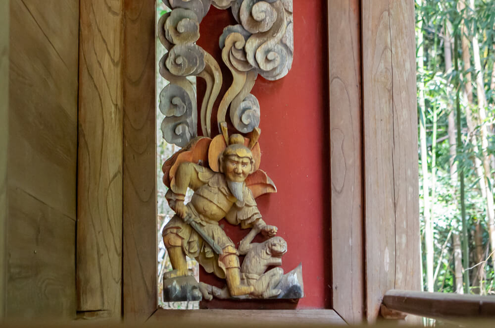 刀を持つ男と猿の彫刻