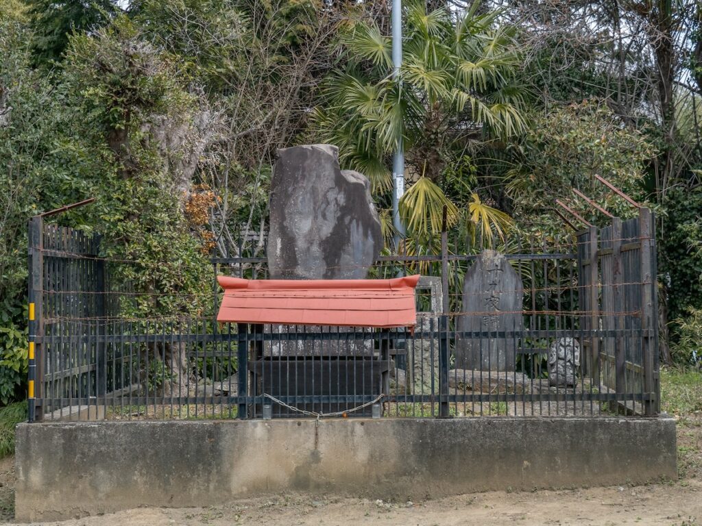 鉄柵で保護された不動明王の石碑